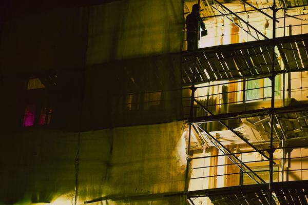 Scaffolding on a building under construction, lit at night