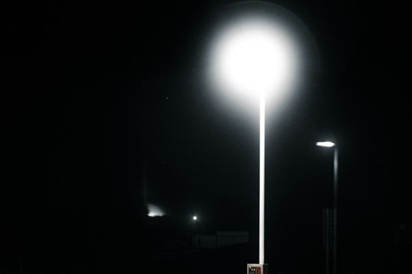 An empty parking lot under a single light at night